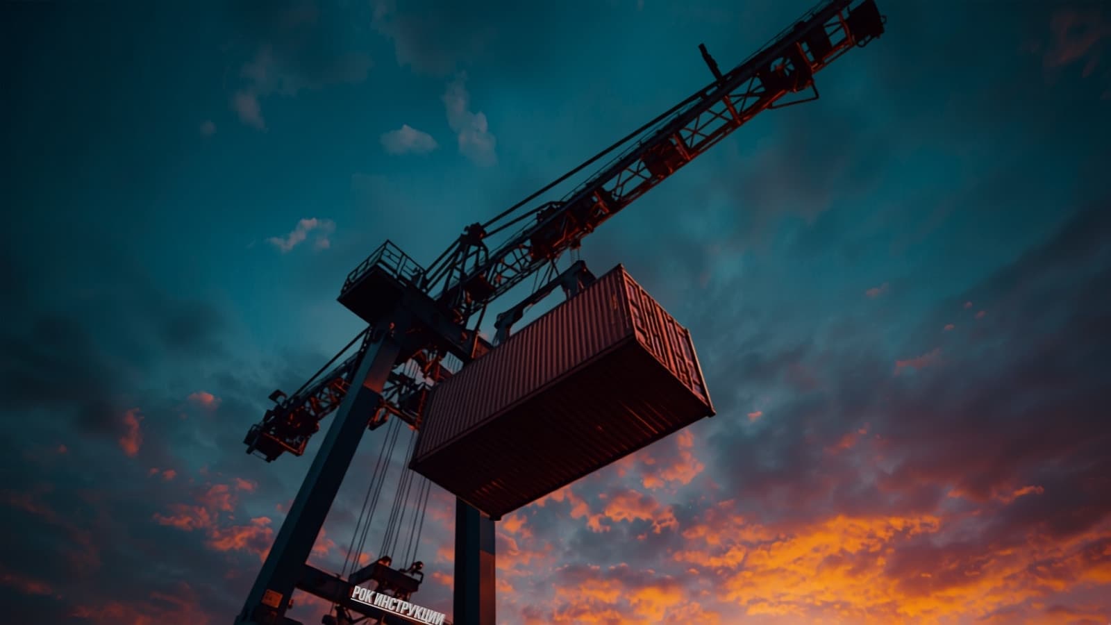 Gantry crane lifting a container at dusk